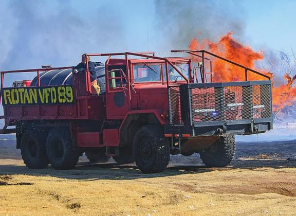 Members of the Rotan Volunteer Fire Department attacking flames that burned through southwestern Rotan last week.