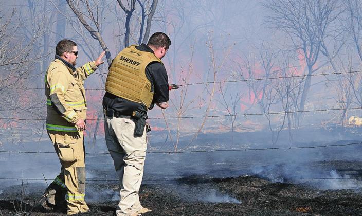 Kody King of Rotan Volunteer Fire Department and Tanner Garcia Fisher County Sheriff Department have to cut a fence inorder to get into the property to battle flames.