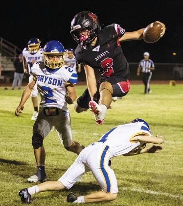 Left: Aspermont's Grayson English Hurdles a Cowboy defender on his way to the endzone during the Hornets' contest with Bryson last