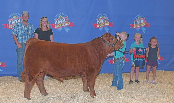 Maci Hjelmervik proudly shows off her Reserve Champion Red Angus at the West Texas Fair and Rodeo Steer Show wiht her family Johnathan and Nicole, sister Kynadi and Kylee Barnett