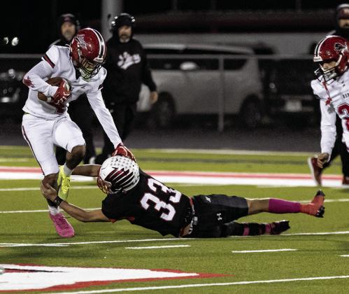 Left: Roby's Camden Carrion fights through a leg tackle during the Lion's district contest with Hermleigh last Friday night. Photo by: Mark Martinez