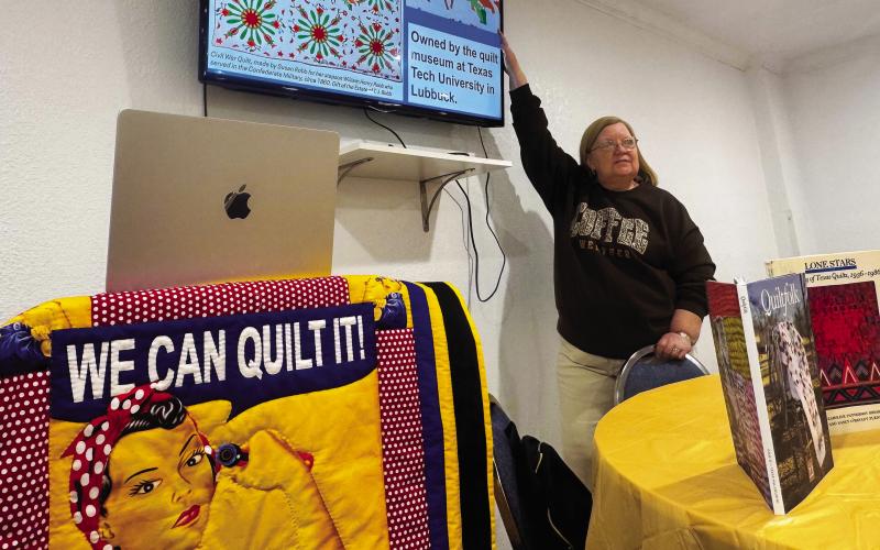 During her presentation, Ellen Goodwin points to a Civil War-era quilt made by Susan Robb for her stepson, William Henry Robb, who served in the Confederate Army. The quilt is now housed at the quilt museum at Texas Tech University. PHOTO BY JEFF HURT