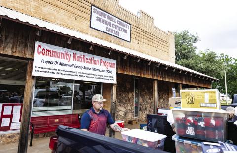 Carse Crews loads belongings from the Stonewall Senior Citizens Center into a pickup Sunday after stormwater poured through the building’s exposed roof. More than 50 volunteers helped empty nearly the entire center, clearing the way for restoration work expected to take four to six months. PHOTO BY MARK MARTINEZ