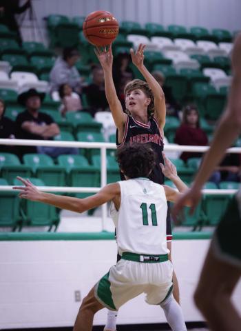 (Pictured Right) Hornet Junior Seth Johnson puts up three over a Piper defender during the Hornets' 65-47 win over Hamlin Tuesday night. Photo by Mark Martinez