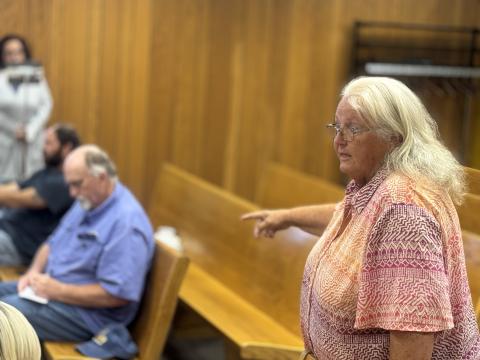Rebecca Gardner Hudnel addresses the Fisher County Commissioners Court during the Oct. 13 meeting, expressing frustration over law enforcement response times and investigative practices while Sheriff Dickson takes notes.