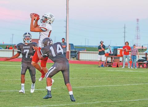 Roby senior Gunner Helm goes up to recieve a pass over Mustang defenders. Photo by: Mark Martinez