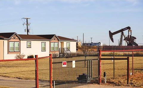 A pumpjack next to a home in Gardendale. Texas is the nation’s top natural gas producer but the state has started exporting more of it to other countries, which contributes to rising utility costs for Texans. Credit: Eli Hartman for The Texas Tribune