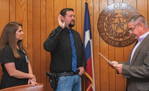 Fisher County Judge Ken Holt swears in new Chief Deputy Tanner Garcia, as his wife Courtney stands by his side.
