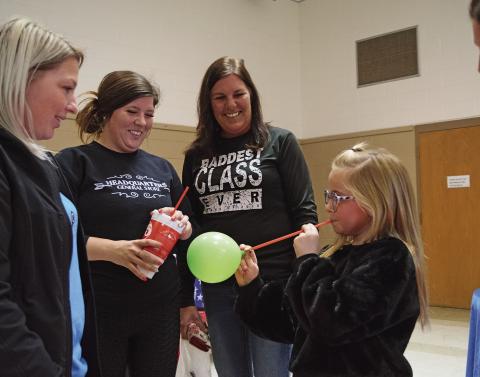 Stonewall Hospital staff demonstrate the effects of smoking as third-grader, Stella Hand, who tries to use a drinking straw to blow up a balloon.