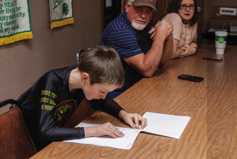 Not quite voting age, Roby CISD student Carson Evans, son of Precinct 4 Commissioner Micah Evans, reads the results of early voting while Fisher County Precinct 1 Commissioner Gordon Pippin looks on. PHOTO BY JEFF HURT