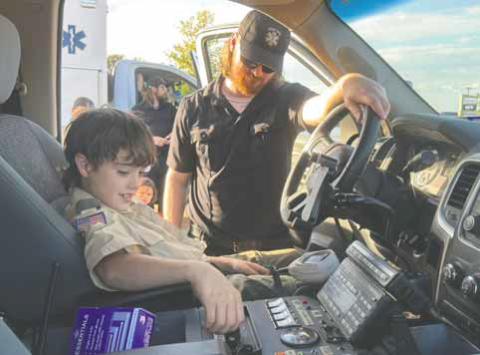 Local Boy Scout Pepper Gomez works the sirens in the front seat of the Fisher County ambulance during National Night Out last week. PHOTO BY JEFF HURT