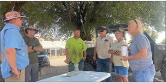 Rory Burroughs (pictured far left) coordinates with a group of Rotan volunteers that were kind to answer a call for help, lending their hands and equipment to remove debris from 12 properties on Tuesday.