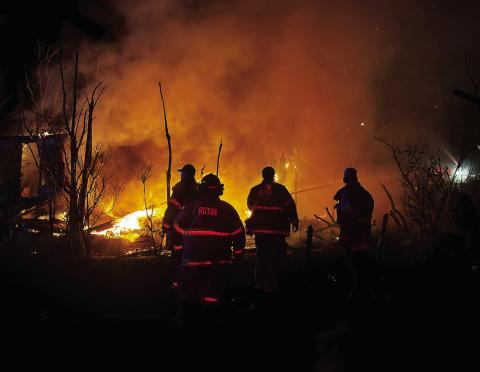 Rotan and Roby fire personnel work to prevent the spread of a fire that destroyed a vacant house on McArthur Ave in Rotan late Sunday evening