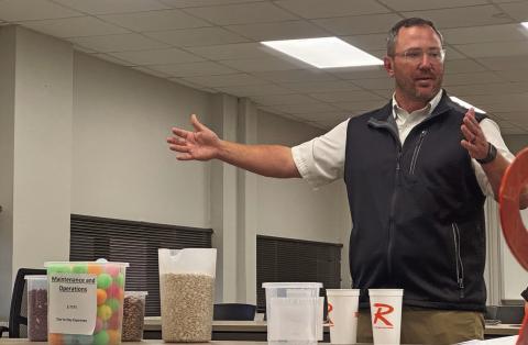 Rotan ISD Superintendent Michael Rudewick uses a variety of dried beans and a series of graduating containers to simplify the state’s education funding model during Monday night’s board meeting.