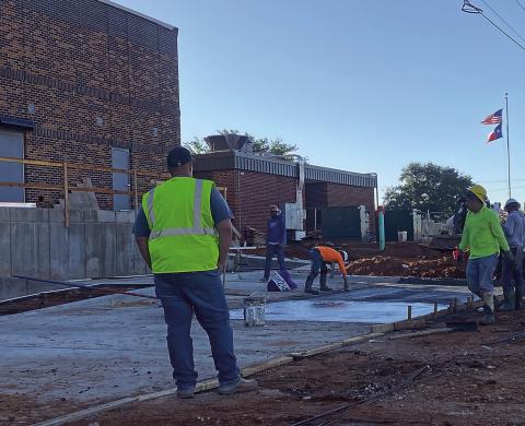 Construction is nearing completion at the Rotan Gymnasium and Cafeteria as workers pour concrete for parking places.