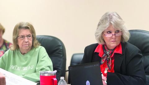 Ruthie Elkins (left) and Ellen Abernathy, president of the Stonewall Memorial Hospital District Board, listen as administrators present financial reports during the board’s February meeting.