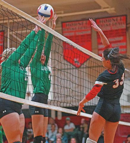 Lady Hornet Addi Shugart spikes the ball over Lady Eagle defenders in Tuesday's win over Ropes. PHOTO BY MARK MARTINEZ