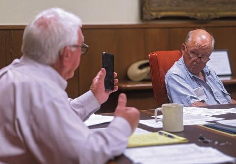 Stonewall County Judge Ronnie Moorhead and Commissioner Gary Myers listen in as County Attorney Riley Branch provides legal guidance regarding the county’s cemetery maintenance contract.