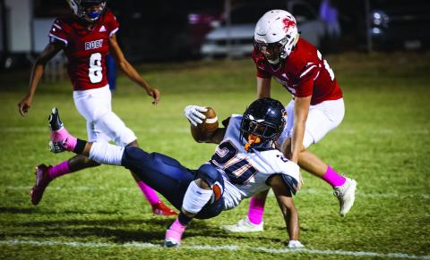 Lion senior Brennan Faucett rips down Bulldog ball carrier in last Friday's loss to Ira.