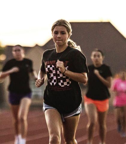 Lady Lion XC senior Lilly Benson leads the pack during the teams' morning workout. PHOTO MARK MARTINEZ