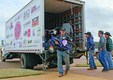 Rotan Methodist Church member Brett Clemmos helps unload a truck full of bikes, sports equipment, and toys with fellow parishioners waiting for the next load from Larry Sauls &amp; Friends in their third annual delivery.