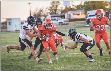 Rotan Sophomore Jose Garza weaves through Cowboy defenders during the Hammers 44-39 win over Woodson last Friday night. Photo by Mark Martinez