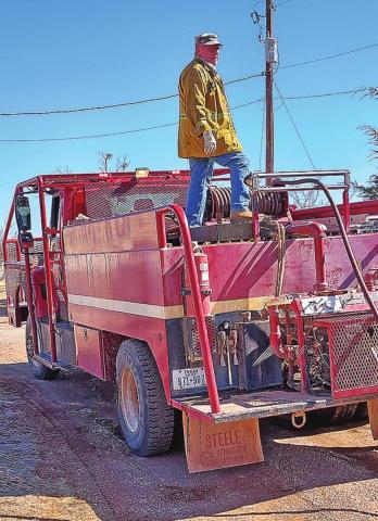 Pictured are Volunteer Firefighter Larry Coats on top of Brush 19 insuring the hose reel doesn’t jam.