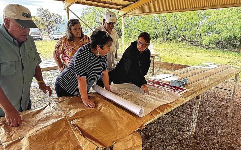 Locals check the Newman Cemetery map for reserved spots no longer needed. Photo Submitted by
