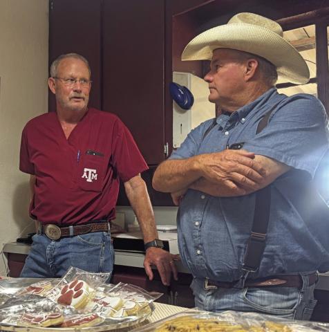 Dr. Vick Burk shares cookies and conversation with Rotan Minister, Jeff Sedberry, who stopped in for a visit during Burk‘s retirement party last week.