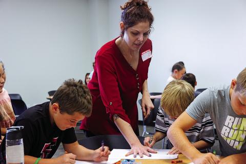Alicia Barton with the Abilene Recovery Council lends a hand to Aspermont ISD third-graders during a project to help students learn concepts for positive decision making
