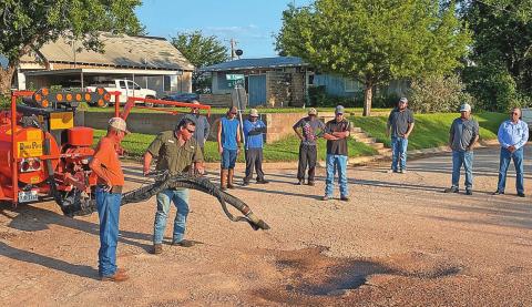 Mayor Pete Garcia and Rotan Director of Public Works Brian James watched along with fellow councilmen and city work crew as representatives with Texas Patcher demonstrated its DuraPatcher machine's ability when repairing this troublesome pothole.