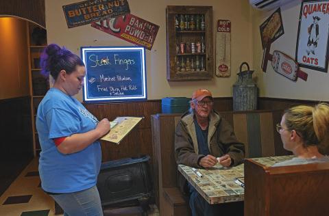 Brittnay Gonzalez takes Mike Bookman and his daughter's order during their lunch rush at Hickman's Restaurant, now open to full capacity since Gov. Abbott lifted restrictions earlier this month in the efforts to reopen Texas 100 percent.