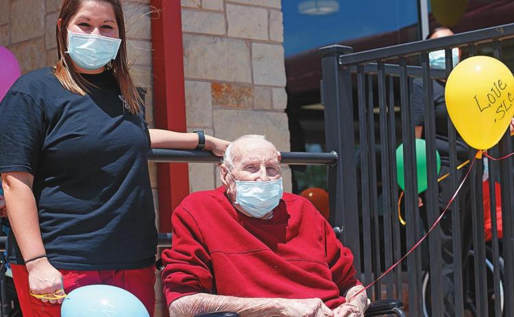 Megan Blocker LVN and Stonewall Living Center resident Bobbie Boyles prepare to release balloons for the final day of celebration during Nursing Home Week.