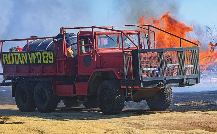 Members of the Rotan Volunteer Fire Department attacking flames that burned through southwestern Rotan last week.