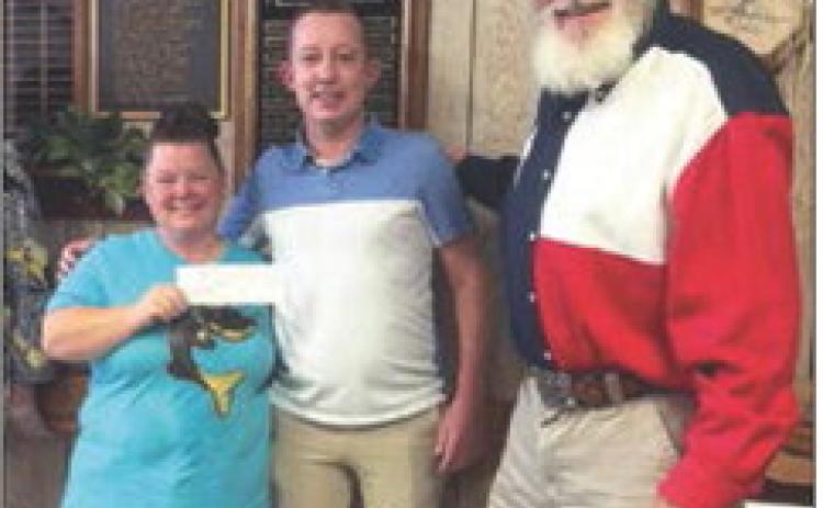 Stonewall Senior Citizens Director Becky Flores and longtime board member, George Abernathy accepts a $500 donation check from County Attorney Riley Branch.