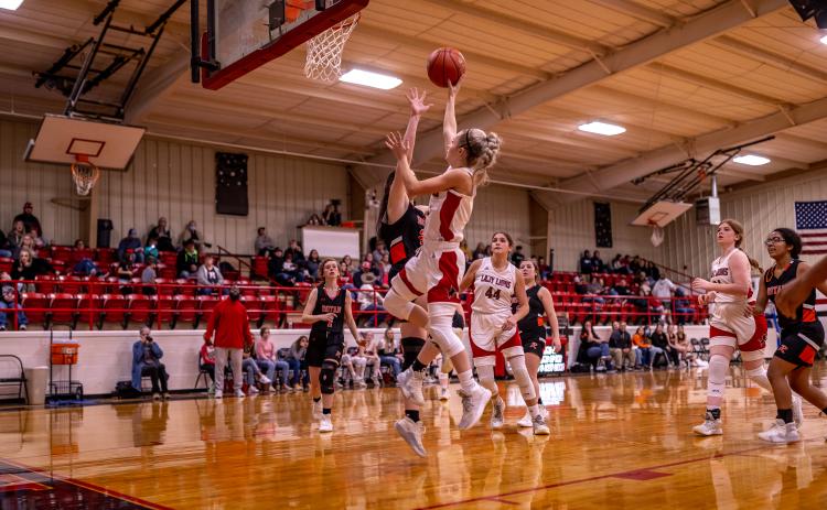 Lady Lion, Chasity Benson lays up a shot over Lady Yellowhammer, Sterling Bowen during the final district match up against the Lady Yellowhammers