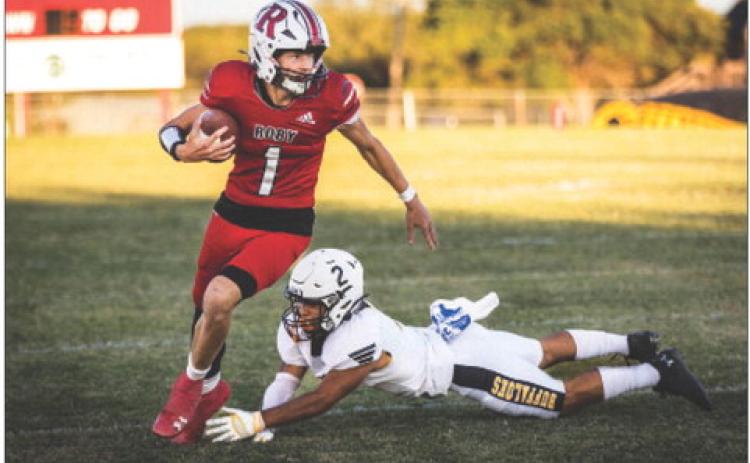 Sophomore Kullen Daniel slips a tackle from a buffaloe defender during Roby's 65-48 win over Petersburg last Friday night in Roby. The Lions found themselves in a shootout early on in the match, trading blows until the end of the first half leading 30-28. Roby would come out strong in the second half, outscoring the the Buffs 35-20 to come out on top. The Lions improve to 3-1 on the season and will take on Baird this Friday at 7:30pm in Roby. Photo by: Mark Martinez