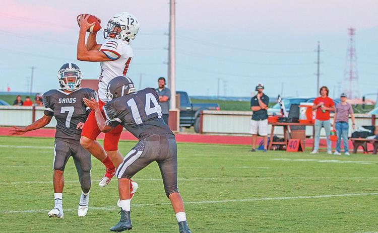 Roby senior Gunner Helm goes up to recieve a pass over Mustang defenders. Photo by: Mark Martinez