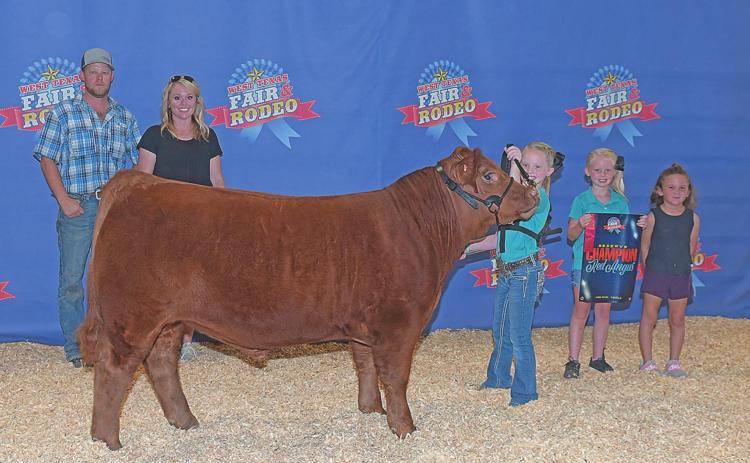 Maci Hjelmervik proudly shows off her Reserve Champion Red Angus at the West Texas Fair and Rodeo Steer Show wiht her family Johnathan and Nicole, sister Kynadi and Kylee Barnett