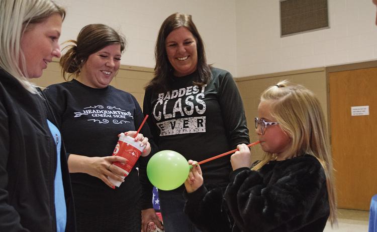 Stonewall Hospital staff demonstrate the effects of smoking as third-grader, Stella Hand, who tries to use a drinking straw to blow up a balloon.