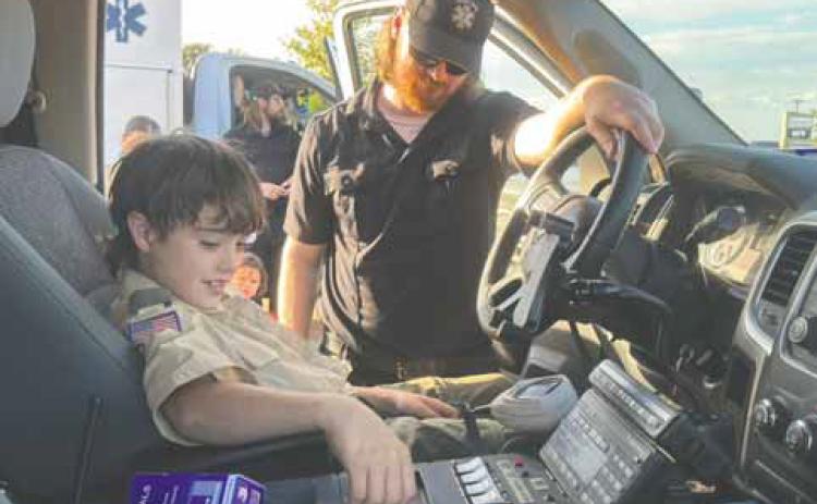 Local Boy Scout Pepper Gomez works the sirens in the front seat of the Fisher County ambulance during National Night Out last week. PHOTO BY JEFF HURT