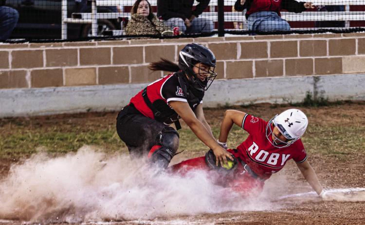 Left: Roby's Ariela Castaneda slides into home plate to beat the tag from Aspermont catcher Peyton Calamaco during the Lady Lion's 20-13 win over the Lady Hornets Tuesday night. With the win, the Lady Lions improve to 2-2 in District play. PHOTO BY MARK MARTINEZ