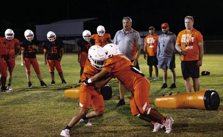 Rotan Head Coach Troy Sparks leads his team through tackling drills at Rotan's Midnight Madness Practice. Photo by Mark Martinez.