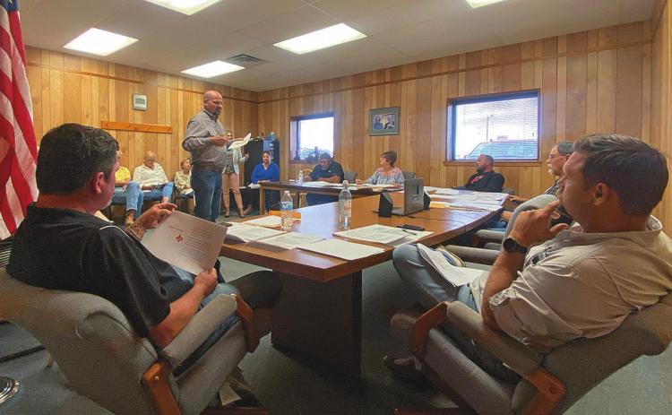 Aspermont City Council Members, Matt Fraser and Chris Lipham consider Danny Barrett with TCG's proposal for mitigating dilapidating structures along Aspermont's main corridor.