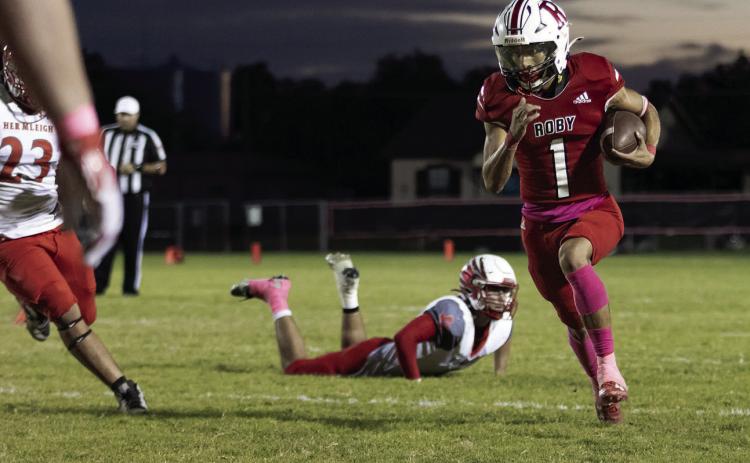 Roby's Keegan Encizo slips Cardinal defenders en route to the endzone during the Lions' 6-52 loss to Hermleigh last Friday. Encizo would record only score of the night for Roby. Photo by Mark Martinez