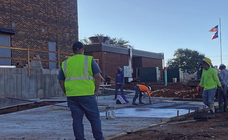 Construction is nearing completion at the Rotan Gymnasium and Cafeteria as workers pour concrete for parking places.