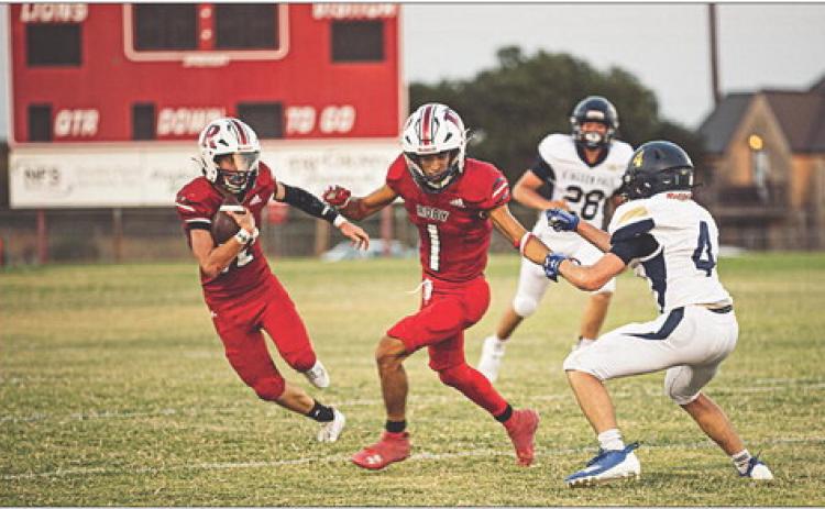 Sophomore Lion Gage Barrera takes the ball upfield covered by Senior Lion Keegan Encizo during Roby's 20-56 loss to Lubbock Kingdom Prep Academy last Friday night at home. The Lions will take the field again this Friday night at home against Irion County for Homecoming. Photo by Tricia Hurt