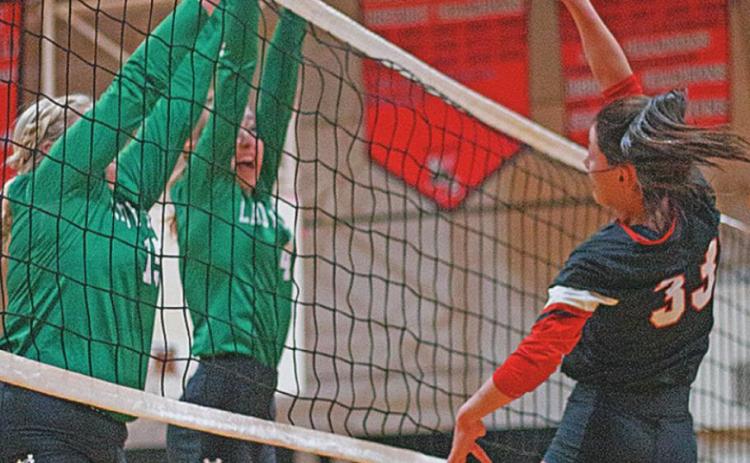 Lady Hornet Addi Shugart spikes the ball over Lady Eagle defenders in Tuesday's win over Ropes. PHOTO BY MARK MARTINEZ