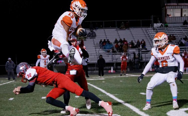 Sophomore Jaxon Warren hurdles Hermleigh defender while fielding a kick-off. (Photo by Mark Martinez)