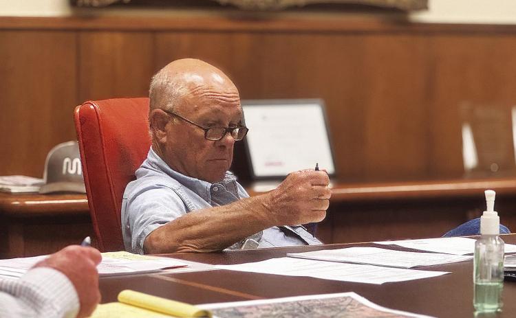 Stonewall County Commissioner Gary Myers reviews budget considerations during a budget workshop held when the court met in late June. PHOTO BY MARK MARTINEZ